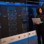 Mujer con computadora en servidor.