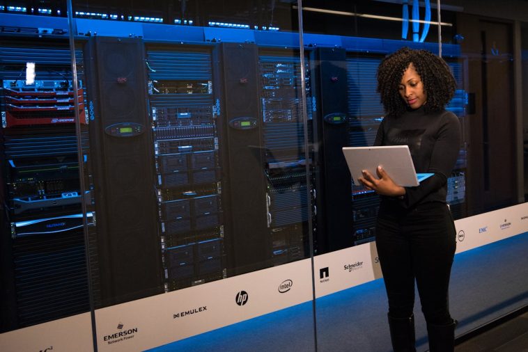 Mujer con computadora en servidor.